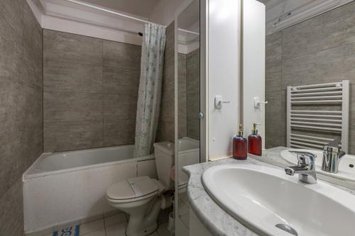 une salle de bain avec un lavabo, des toilettes et une baignoire dans l'établissement Le Solaire, aux Angles