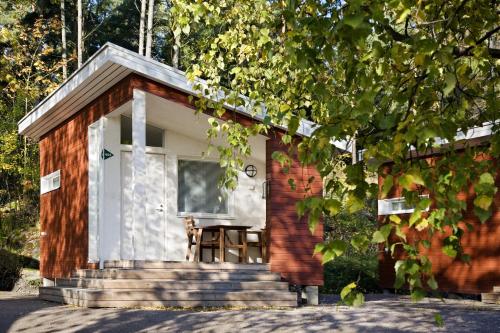 a small house with a porch and a table at Rastila Camping Helsinki in Helsinki
