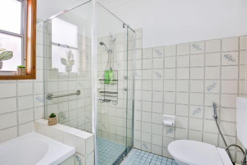 Un baño con ducha, inodoro y lavabo. en Rockpool Pet Friendly 1 Min Walk to Beach, en Culburra Beach
