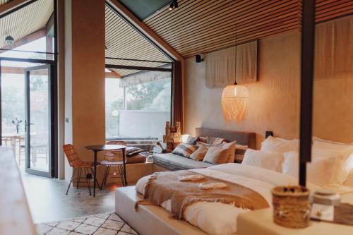 a bedroom with a large bed and a living room at Comme chez Soye - Private Wellness in Soye