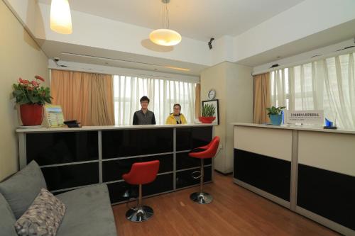 two men standing at a bar in a waiting room at Westlake 7 Service Apartment in Hangzhou