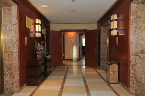 a hallway of a hotel with wooden walls and tile floors at Westlake 7 Service Apartment in Hangzhou