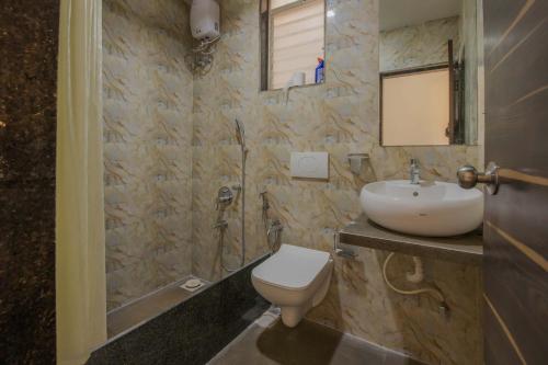 a bathroom with a toilet and a sink at StayVista's Vine & Splash - Riverside villa with an infinity pool and indoor games in Karjat