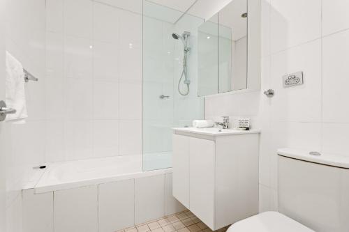 een witte badkamer met een toilet en een douche bij Charming Modern Apartment with City Views DUPLICATE in Sydney