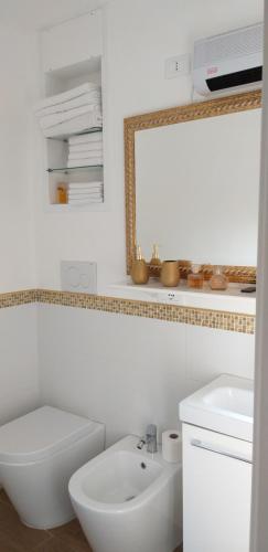 a bathroom with a sink and a toilet and a mirror at Burano Cà Comare in Burano