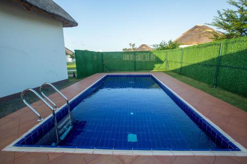 a swimming pool in a backyard with a fence at Aya Sophia Villa Garden Hotel in Dar es Salaam