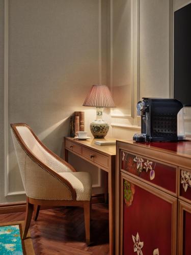 a desk with a chair and a lamp on it at Grand Mercure Hanoi in Hanoi