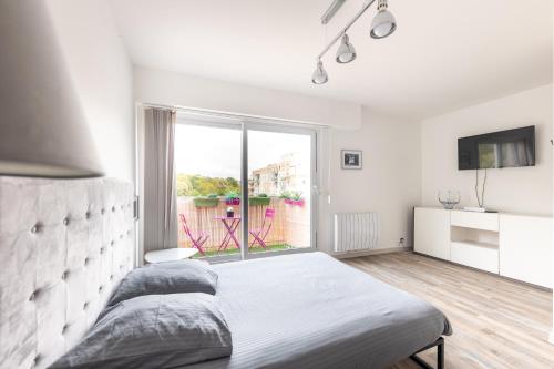 um quarto branco com uma cama grande e uma janela em Studio neuf proche Disneyland Paris em Meaux