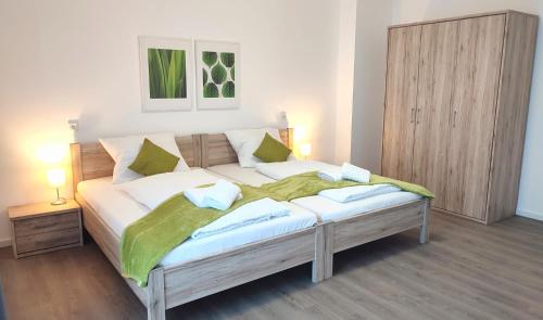 een slaapkamer met een groot bed en een groene deken bij greenpartment Boardinghousehotel Kelheim in Kelheim