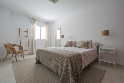 biała sypialnia z łóżkiem i krzesłem w obiekcie Terraza de Radazul w mieście Radazul