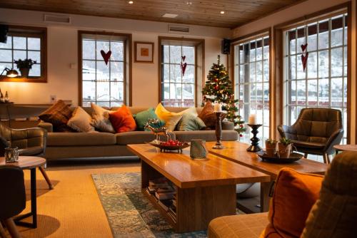 a living room with a couch and a christmas tree at Flåmsbrygga Hotel in Flåm