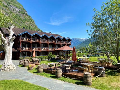 a large building with tables and chairs in front of it at Flåmsbrygga Hotel in Flåm