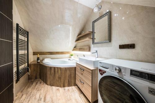 a bathroom with a washing machine and a sink at Resort Slunce in Harrachov