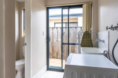 een badkamer met een wastafel en een toilet en een raam bij Lime Tree Haven in Margaret River Town