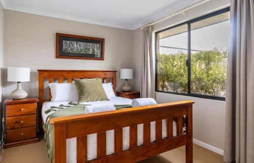 een slaapkamer met een houten bed en een raam bij Lime Tree Haven in Margaret River Town