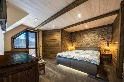 a bedroom with a bed and a brick wall at Resort Slunce in Harrachov