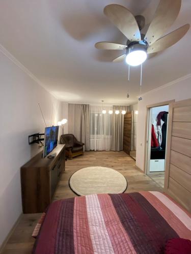 a bedroom with a bed and a ceiling fan at Прелестное жильё у Akropole, бесплатная парковка. in Rīga
