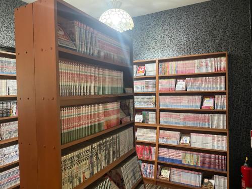 a library filled with lots of books on shelves at Hotel ニャンだふる in Himeji