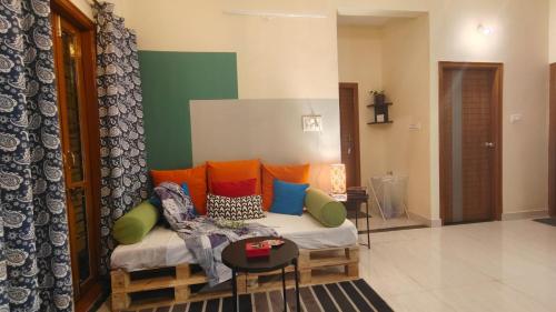a living room with a couch with colorful pillows at 2390 Home Tales by Tipiverse, HSR Layout in Bengaluru