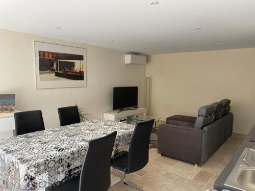 a dining room with a table and chairs and a television at L échappée belle in Vallon-Pont-dʼArc