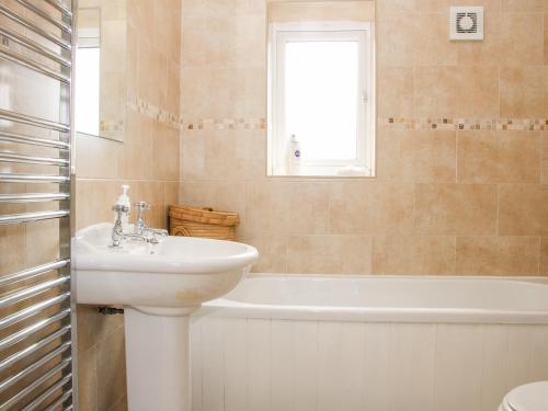 een badkamer met een wastafel en een bad bij Camden Cottage in Kidderminster