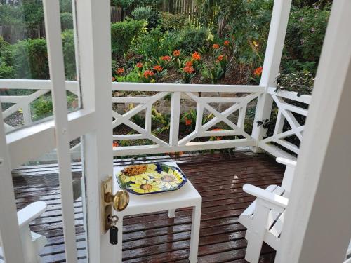 a plate of food sitting on a table on a porch at Yellowwood Lodge in Knysna