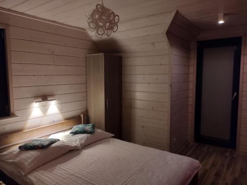 a bedroom with a bed in a room with wooden walls at Cztery Pory Roku - kominek, sauna, jacuzzi in Zarzecze