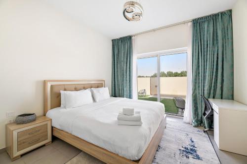 a bedroom with a bed and a large window at Spacious & Private Townhome - 5 mins drive to Al Maktoum Airport in Dubai