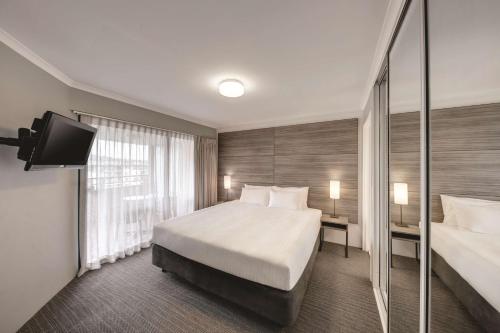 ein Hotelzimmer mit einem Bett und einem TV in der Unterkunft Adina Serviced Apartments Canberra James Court in Canberra