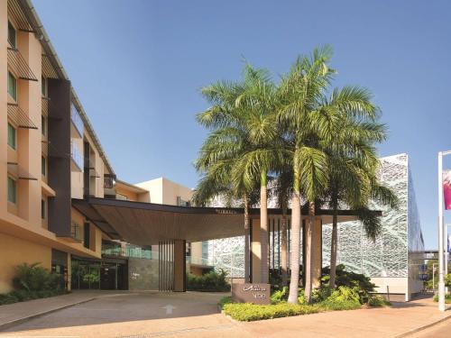 a group of palm trees in front of a building at Adina Apartment Hotel Darwin Waterfront in Darwin