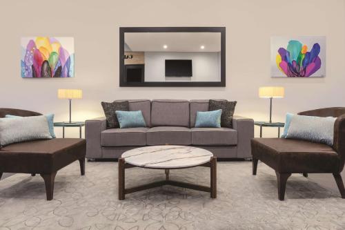 a living room with a couch and two chairs and a table at Adina Apartment Hotel Perth Barrack Plaza in Perth
