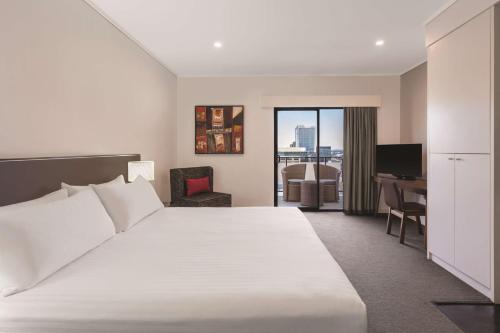 Cette chambre comprend un grand lit et un bureau. dans l'établissement Adina Apartment Hotel Perth Barrack Plaza, à Perth