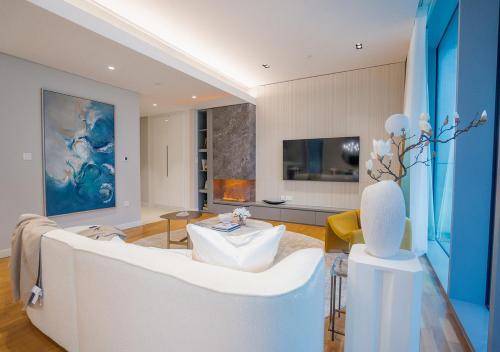 a living room with a white couch and a tv at Bluewaters Residences, Bluewaters Island Dubai - Mint Stay in Dubai