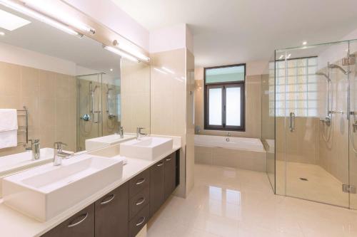 a large bathroom with two sinks and a shower at Adina Apartment Hotel Auckland Britomart in Auckland