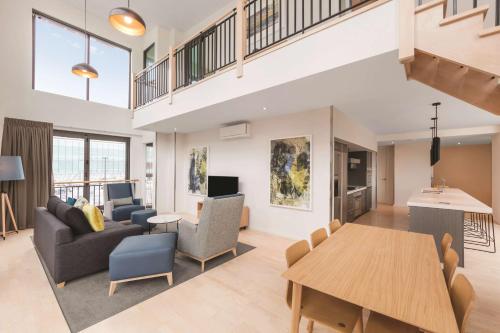 a living room with a couch and a table at Adina Apartment Hotel Auckland Britomart in Auckland