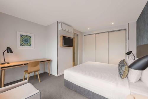 a hotel room with a bed and a desk at Adina Apartment Hotel Auckland Britomart in Auckland
