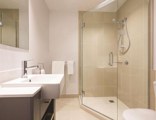 a bathroom with a sink and a shower at Adina Apartment Hotel Auckland Britomart in Auckland