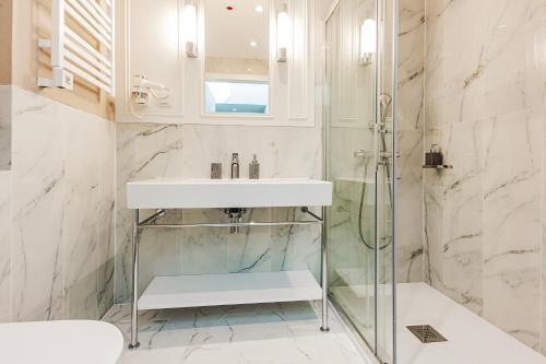 a bathroom with a sink and a shower at VacationClub - Baltic Park Fort Apartament G.508 in Świnoujście