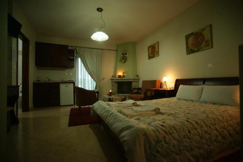 a bedroom with a large bed and a living room at Hotel Orama in Kryonérion