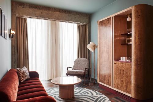 a living room with a couch and a table at The Hoxton, Brussels in Brussels