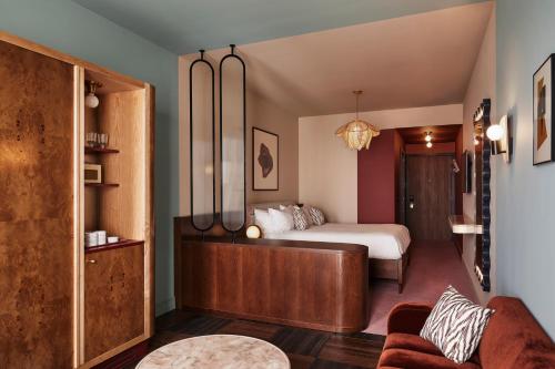 a bedroom with a bed and a couch at The Hoxton, Brussels in Brussels