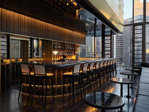 a bar in a restaurant with a view of the city at A by Adina Sydney in Sydney