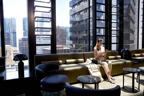 a woman sitting on a couch in a building at A by Adina Sydney in Sydney