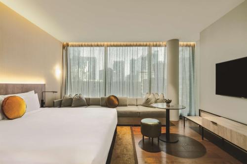 a hotel room with a large bed and a couch at A by Adina Sydney in Sydney