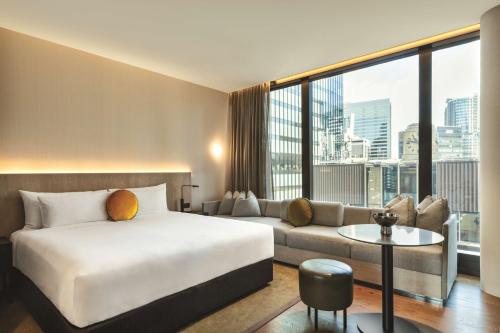 a hotel room with a bed and a couch at A by Adina Sydney in Sydney