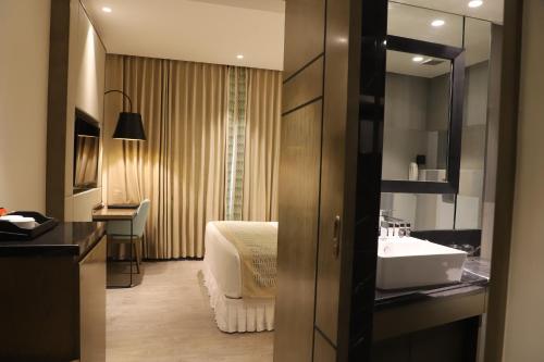 a hotel room with a sink and a bed at THE CRUZE PREMIUM BOUTIQUE HOTEL in Jamshedpur