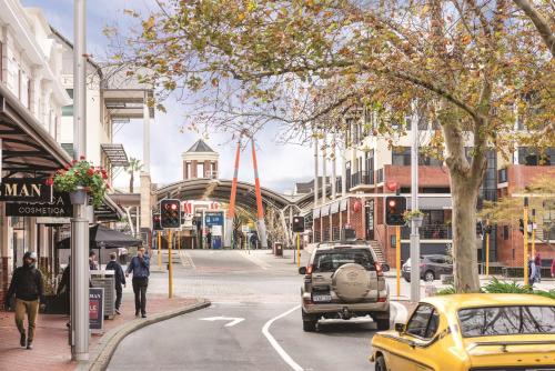 a city street with a yellow car driving down the street at Vibe Hotel Subiaco Perth in Perth