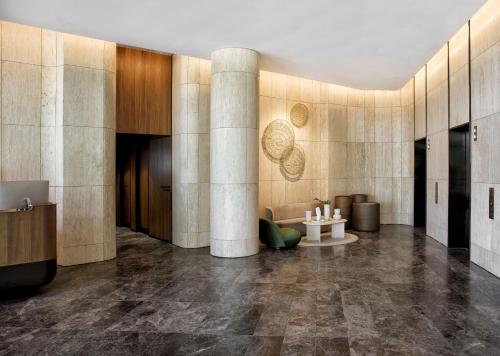 a lobby with columns and a couch and a table at A by Adina Canberra in Canberra