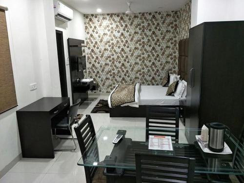 sala de estar con mesa de cristal y cama en Hotel Mandakini Lush By WB Inn, en Kānpur