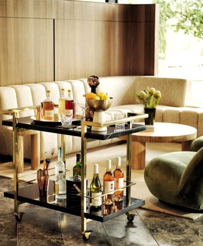 a living room with a table with bottles of wine at A by Adina Canberra in Canberra
